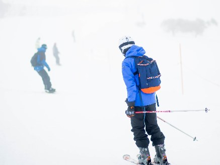 Skiers wearing helmets on a slope
